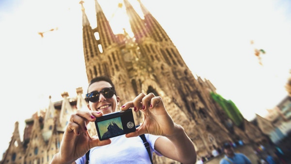En person som tar en selfie foran Sagrada Familia-kirken i Barcelona